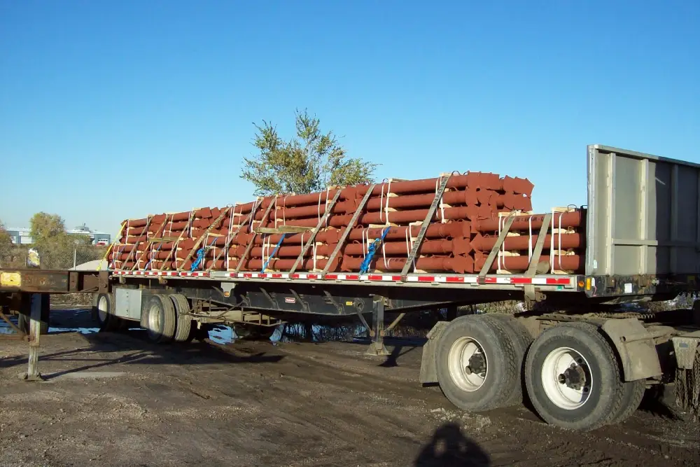 A flatbed truck loaded with pipes